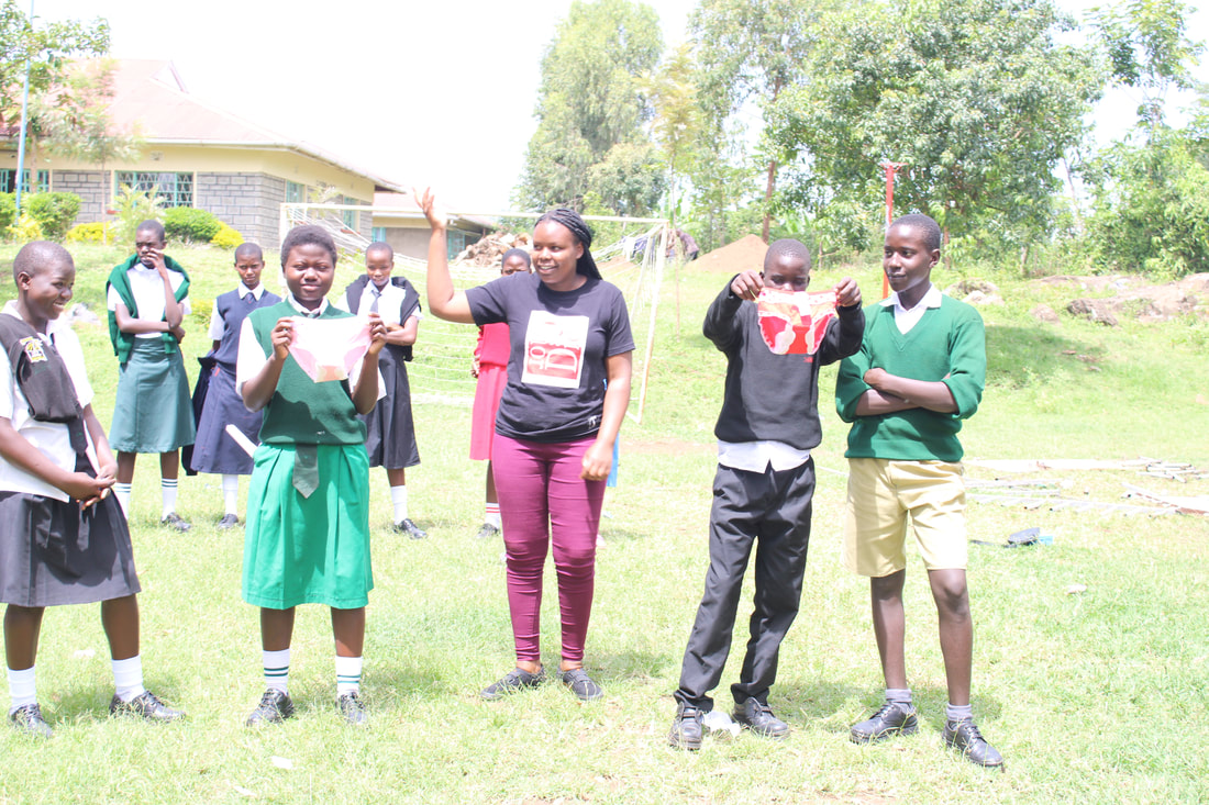 Girls and boys carrying packets of sanitary pads