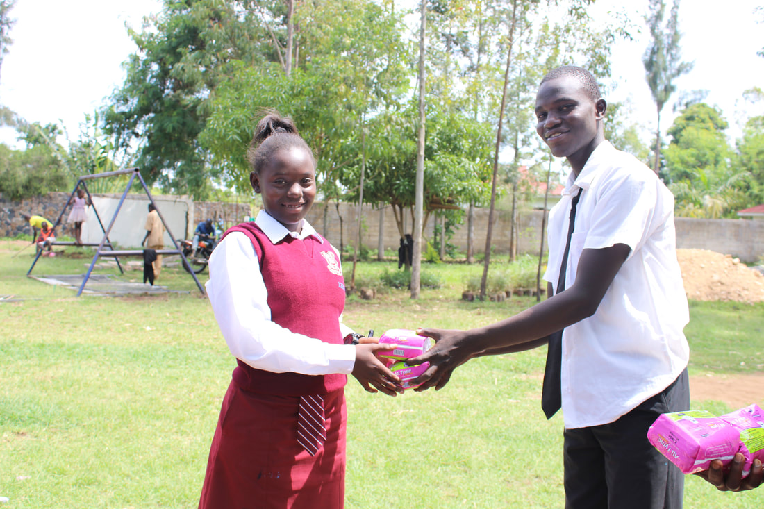 A high school boy handing a packet of sanitary pads to a woman