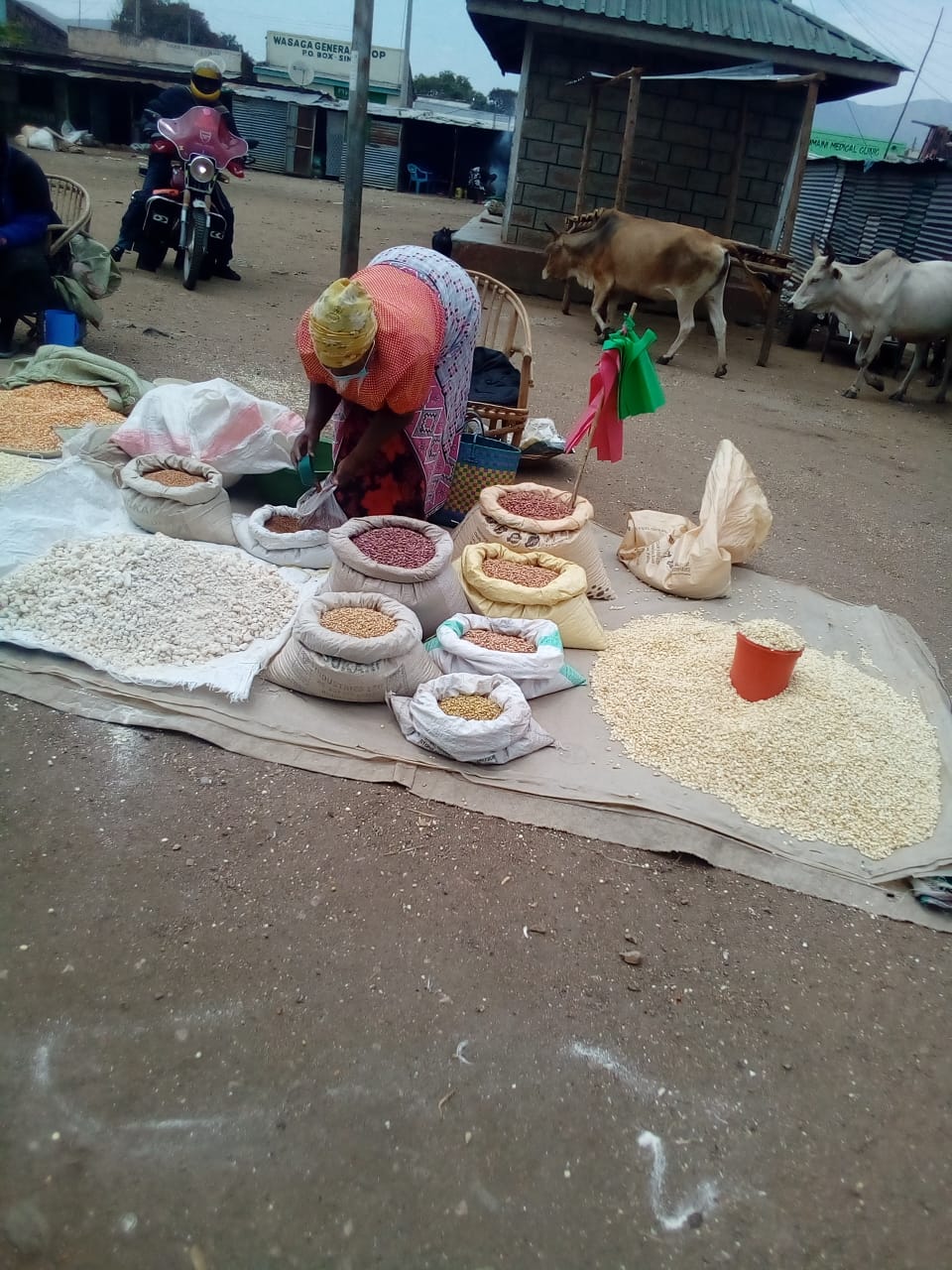 A woman selling cereals at a market in Kisumu